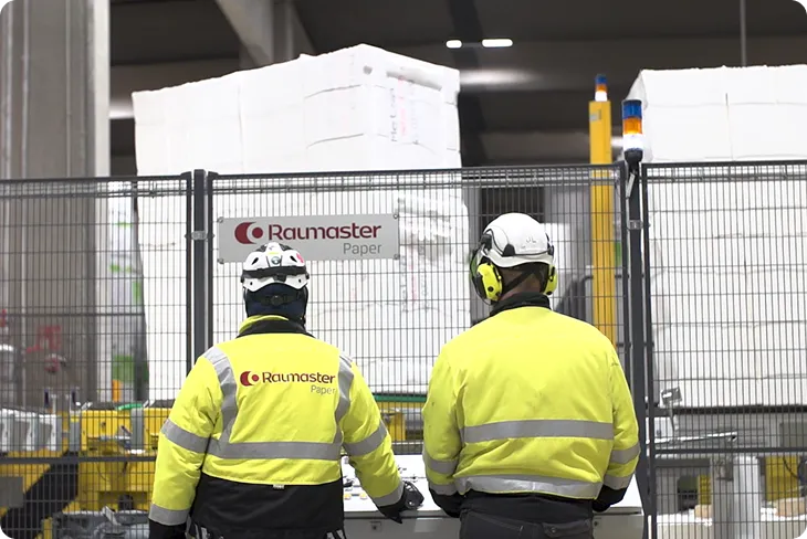 Raumaster operators on the floor by the Raumaster Paper signage